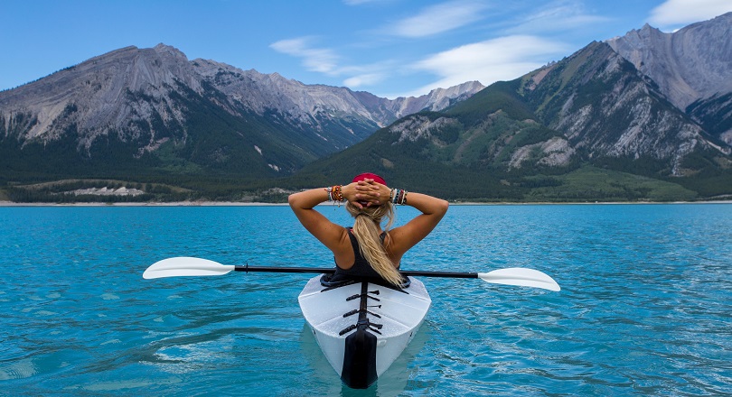 Woman riding a kayak in the middle of a lake - Photo by Kalen Emsley on Unsplash